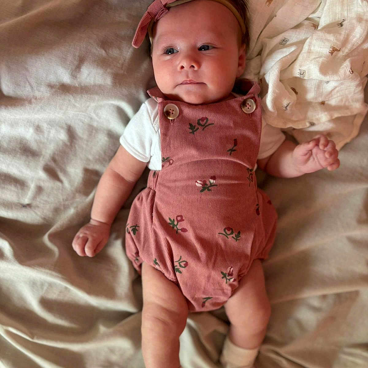 Elora is registered to the contest to win money with this photo: baby, bed, blanket, child, clothing, cute, fabric, foot, hand, headband, indoors, infant, lying_down, person, portrait, romper, skin, sleepwear, socks, soft