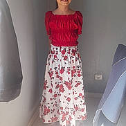 Maidie a rejoint le concours — aidez-le/la à gagner de superbes lots ! child, girl, smile, red_top, floral_skirt, standing, indoor, sunlight, floor, wall, curtain, shoe, footwear, person, portrait, casual_clothing, young, happy, room, light