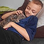 child, boy, cat, pet, couch, pillow, cozy, relaxing, smiling, snuggling, sleepy, indoor, home, comfort, happy, casual_clothing, short_hair, animal, friendship, resting