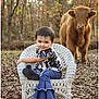 toddler, child, wicker_chair, cow, animal, outdoor, forest, autumn, leaves, nature, portrait, smile, clothing, boots, denim, cute, baby, farm, grass, sunlight