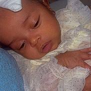 Dior joined the competition — help win amazing prizes! baby, infant, face, hand, white_clothing, headband, sleepy, resting, closeup, soft_texture, blanket, newborn, cute, portrait, delicate, cozy, indoors, peaceful, child, skin