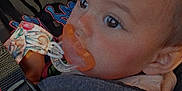 Lucille joined the competition — help win amazing prizes! adult, baby, carrier, child, closeup, clothing, expression, fabric, face, hand, holding, indoor, infant, light, nose_ring, pacifier, person, portrait, shadow, strap