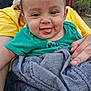 baby, child, tongue_out, green_shirt, yellow_shirt, blanket, hand, outdoor, nature, person, smile, portrait, cute, infant, face, young, happy, clothing, tree, holding