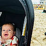 baby, beach, car_seat, child, clothing, cute, daytime, fun, happy, head, infant, outdoor, person, portrait, relaxation, sand, seat, smiling, sunny, vacation