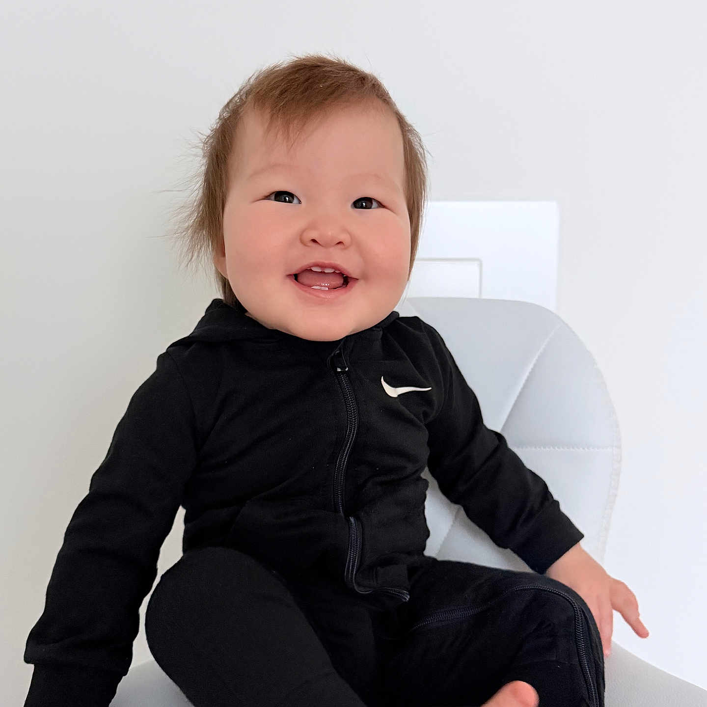 Miray Temirlan joined the competition — help win amazing prizes! baby, black_clothing, casual_wear, child, cute, expression, face, foot, hair, hand, happy, indoor, minimalist_background, nike_logo, portrait, sitting, smiling, toddler, white_chair, young_child