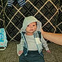 baby, infant, hood, clothing, couch, hand, patterned_fabric, baby_wipes, striped_clothing, indoor, person, sitting, support, casual_wear, comfortable, young_child, portrait, home, soft_lighting, relaxed