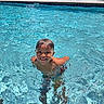 child, boy, swimming_pool, water, smile, sunlight, outdoor, summer, happy, fun, play, recreation, blue, leisure, person, poolside, sunny, young, vacation, joy