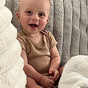 Cooper joined the competition — help win amazing prizes! baby, smiling, happy, infant, child, face, hands, sitting, blanket, texture, cozy, indoor, cute, onesie, young, soft, comfort, portrait, skin, expression
