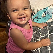 Oaklen is registered to the contest to win money with this photo: toddler, child, smiling, happy, pink_top, hair_bows, indoor, blanket, bag, wood_floor, cute, portrait, person, young_child, baby, cheerful, standing, face, hands, clothing
