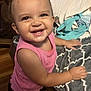 toddler, child, smiling, happy, pink_top, hair_bows, indoor, blanket, bag, wood_floor, cute, portrait, person, young_child, baby, cheerful, standing, face, hands, clothing