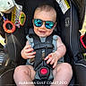Jase is registered to the contest to win money with this photo: baby, child, sunglasses, car_seat, smile, happy, plush_toy, toy, seatbelt, reflection, infant, cute, outdoor, sunlight, legs, feet, hands, person, seat, portrait