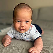 Jagath participe au concours pour gagner de l'argent avec cette photo : baby, infant, face, arms, couch, textured_surface, smile, eyes, clothing, short_sleeves, person, skin, head, indoor, portrait, cute, young_child, tummy_time, expression, closeup