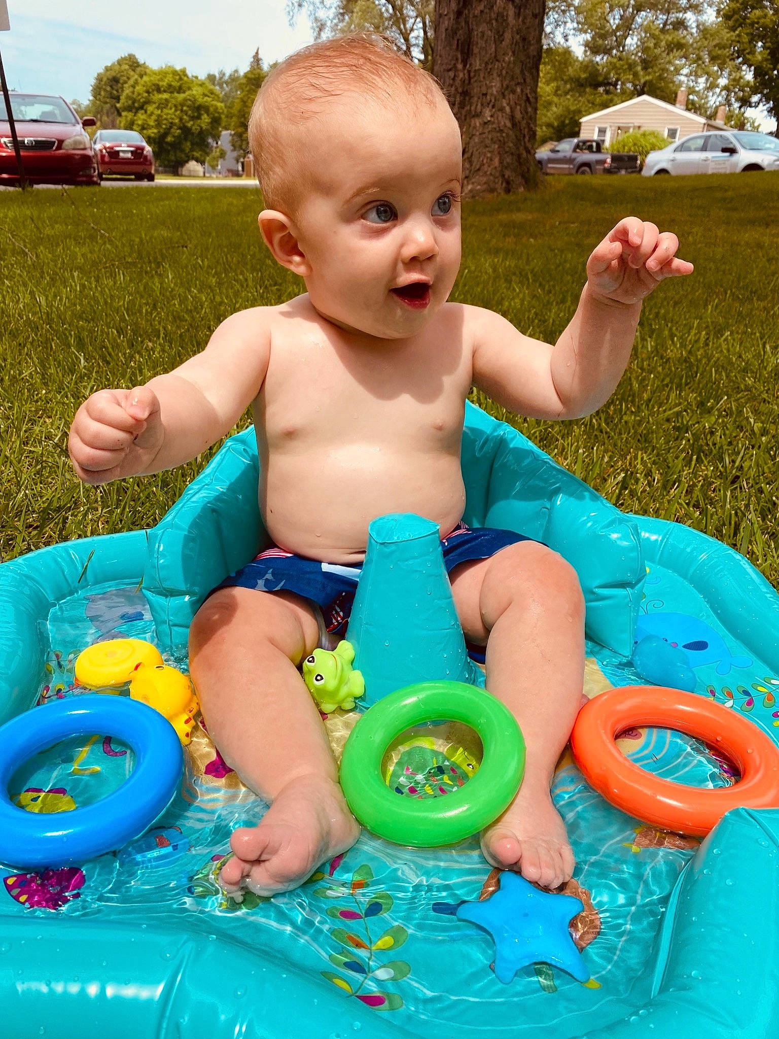 Sora is registered to the contest to win money with this photo: baby, baby_bathing, baby_playing_with_toys, baby_toddler_clothing, blue, child, facial_expression, fun, grass, green, happy, leisure, person, product, recreation, sitting, sky, summer, surprise, toddler