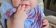 Kas is registered to the contest to win money with this photo: baby, infant, high_chair, face, hand, blue_cloth, purple_stain, indoor, plant, cushion, pattern, seatbelt, child, cute, messy_face, fingers_in_mouth, closeup, person, young_child, expression