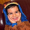 Zian participe au concours pour gagner de l'argent avec cette photo : child, smiling, cute, costume, hood, blue, brown, fuzzy, couch, leather, happy, face, hands, watch, portrait, indoors, young, playful, cozy, cute_expression