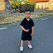 Zian participe au concours pour gagner de l'argent avec cette photo : bicycle, black_clothing, boy, casual, child, confident, daylight, fashion, house, outdoor, road, serious, sidewalk, sneakers, standing, street, summer, sunglasses, village, young_child