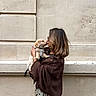 Louki a rejoint le concours — aidez-le/la à gagner de superbes lots ! woman, puppy, dog, holding, kiss, outdoor, beige_wall, brown_jacket, polka_dot_skirt, glasses, cute, pet, affection, portrait, side_view, casual_clothing, light_brown_hair, leash, love, happy