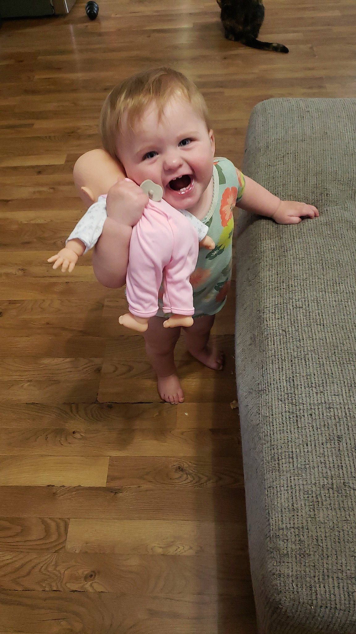 Liv is registered to the contest to win money with this photo: baby, baby_toddler_clothing, cheek, child, comfort, eye, finger, floor, flooring, fun, gesture, happy, hardwood, human_body, person, skin, sleeve, smile, thumb, toddler