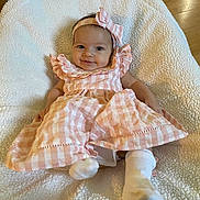 Haisley joined the competition — help win amazing prizes! baby, infant, smile, headband, dress, pink, white, sock, blanket, soft, cozy, indoor, floor, wooden_floor, furniture, child, cute, portrait, happy, lying_down