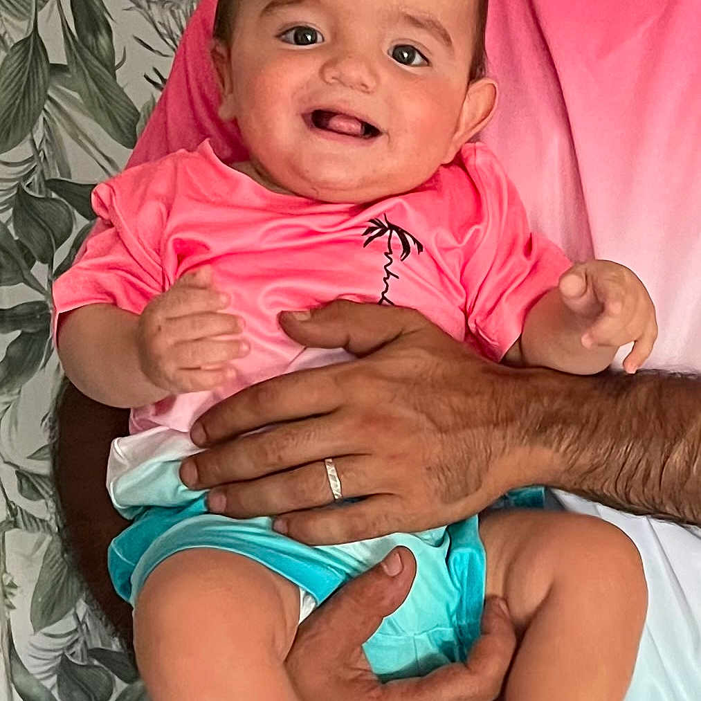 Maïlone participe au concours pour gagner de l'argent avec cette photo : adult, baby, blue_shorts, child, clothing, cute, family, foot, hand, happy, holding, indoor, infant, leaf_pattern, person, pink_shirt, portrait, skin, smiling, wallpaper