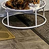 cat, tortoiseshell_cat, pet, animal, feline, lying_down, resting, pet_bed, trampoline, pom_pom_toy, indoor, floor, wood_floor, rug, wall, home, photography, portrait, whiskers, alert