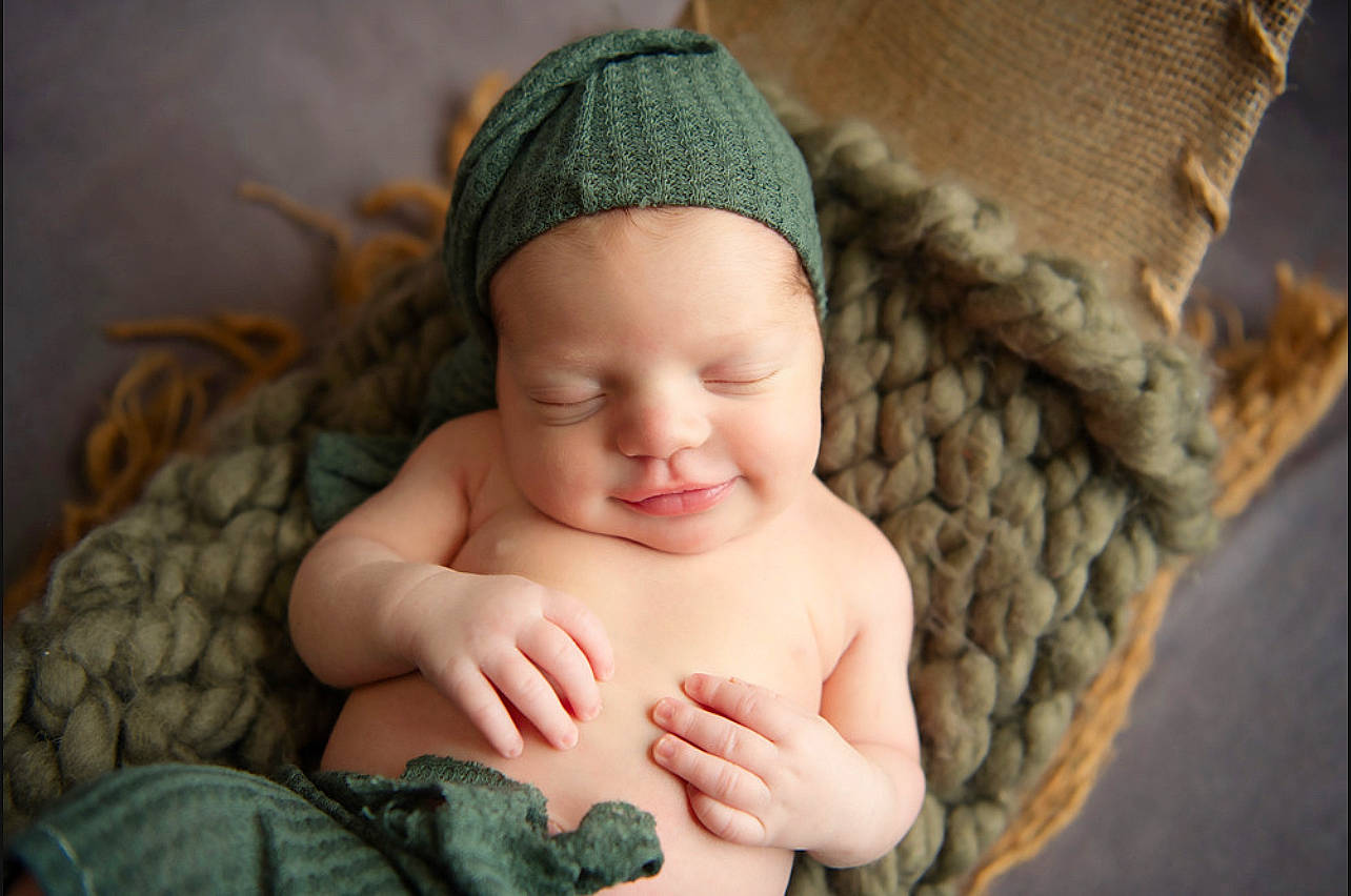 Colt is registered to the contest to win money with this photo: baby, cap, cheek, comfort, eye, eyebrow, face, finger, happy, head, headgear, iris, linens, lip, mouth, nose, person, skin, smile, thumb
