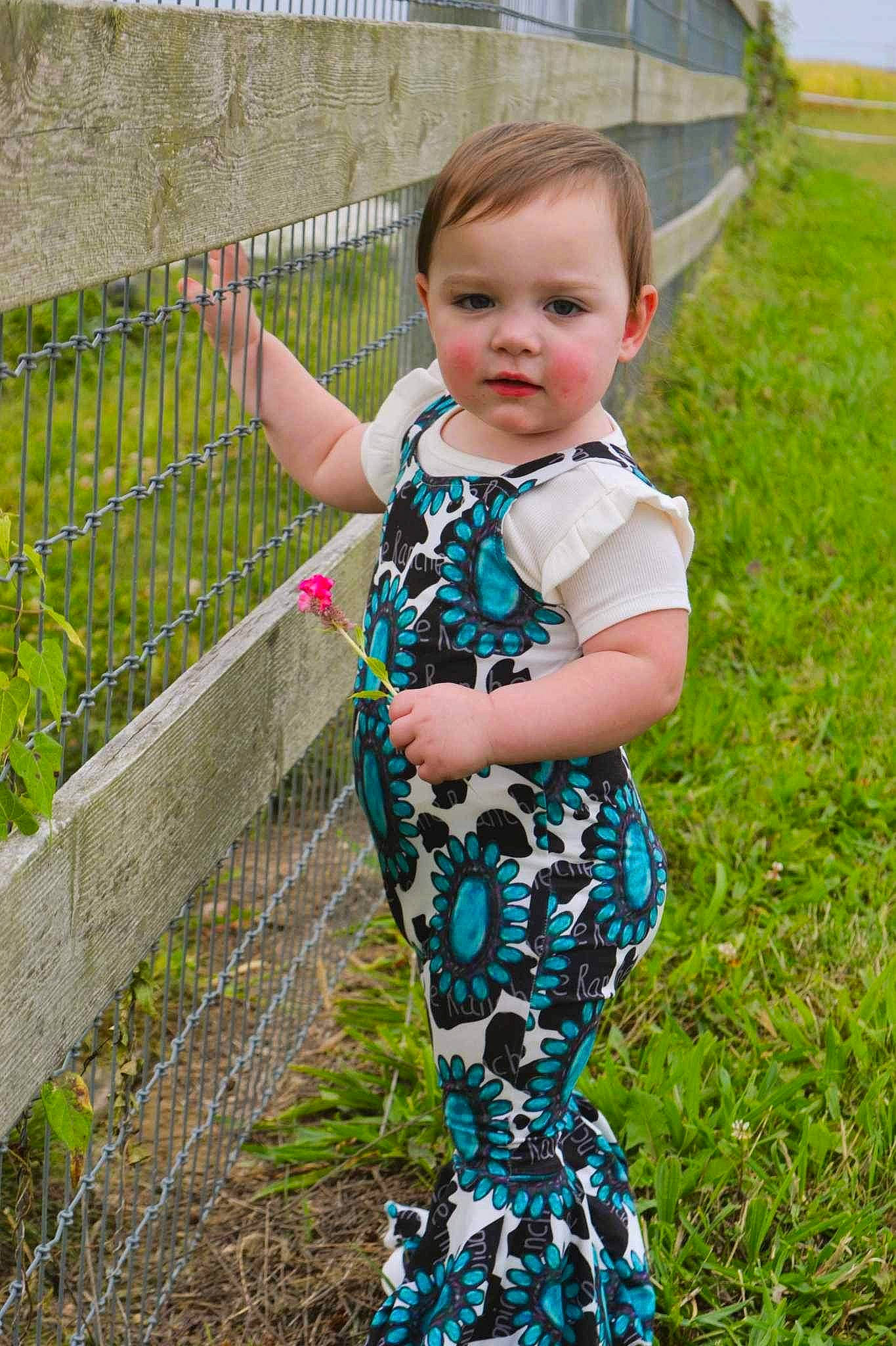 Adeline is registered to the contest to win money with this photo: baby, baby_toddler_clothing, child, clothing, electric_blue, fence, fun, garden, grass, grass_family, grassland, leisure, pattern, people_in_nature, person, plant, sleeve, spring, t_shirt, toddler