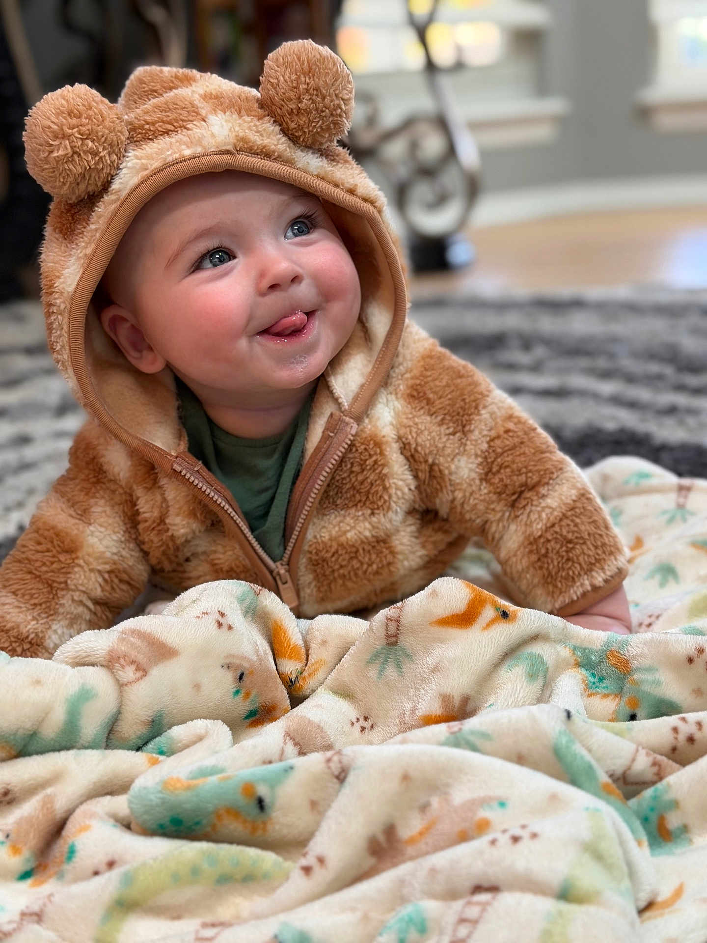 Luca joined the competition — help win amazing prizes! baby, child, hoodie, bear_ears, blanket, soft_texture, playful, tongue_out, cute, indoor, carpet, smiling, infant, cozy, warm_clothing, animal_print, home, portrait, happy, young