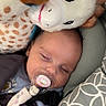 Judith a rejoint le concours — aidez-le/la à gagner de superbes lots ! baby, sleeping, pacifier, plush_toy, giraffe, cushion, patterned, soft, cozy, child, infant, resting, comfort, indoors, cute, peaceful, closeup, head, blanket, nap