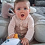 Remi-Mae is registered to the contest to win money with this photo: baby, child, indoor, plush_toy, penguin, cushion, carpet, living_room, furniture, surprised_expression, cute, soft_toys, floor, person, clothing, head, face, hand, blue_eyes, sitting