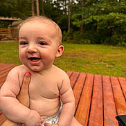 Hayden joined the competition — help win amazing prizes! baby, smiling, outdoor, wooden_deck, greenery, forest, child, diaper, happy, person, nature, cute, skin, hand, holding, infant, daylight, portrait, cheerful, young