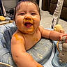 baby, infant, child, smiling, happy, portrait, food, puree, messy_face, mealtime, activity_seat, toy, indoor, home, sitting, bare_chested, brown_hair, close_up, playtime, funny