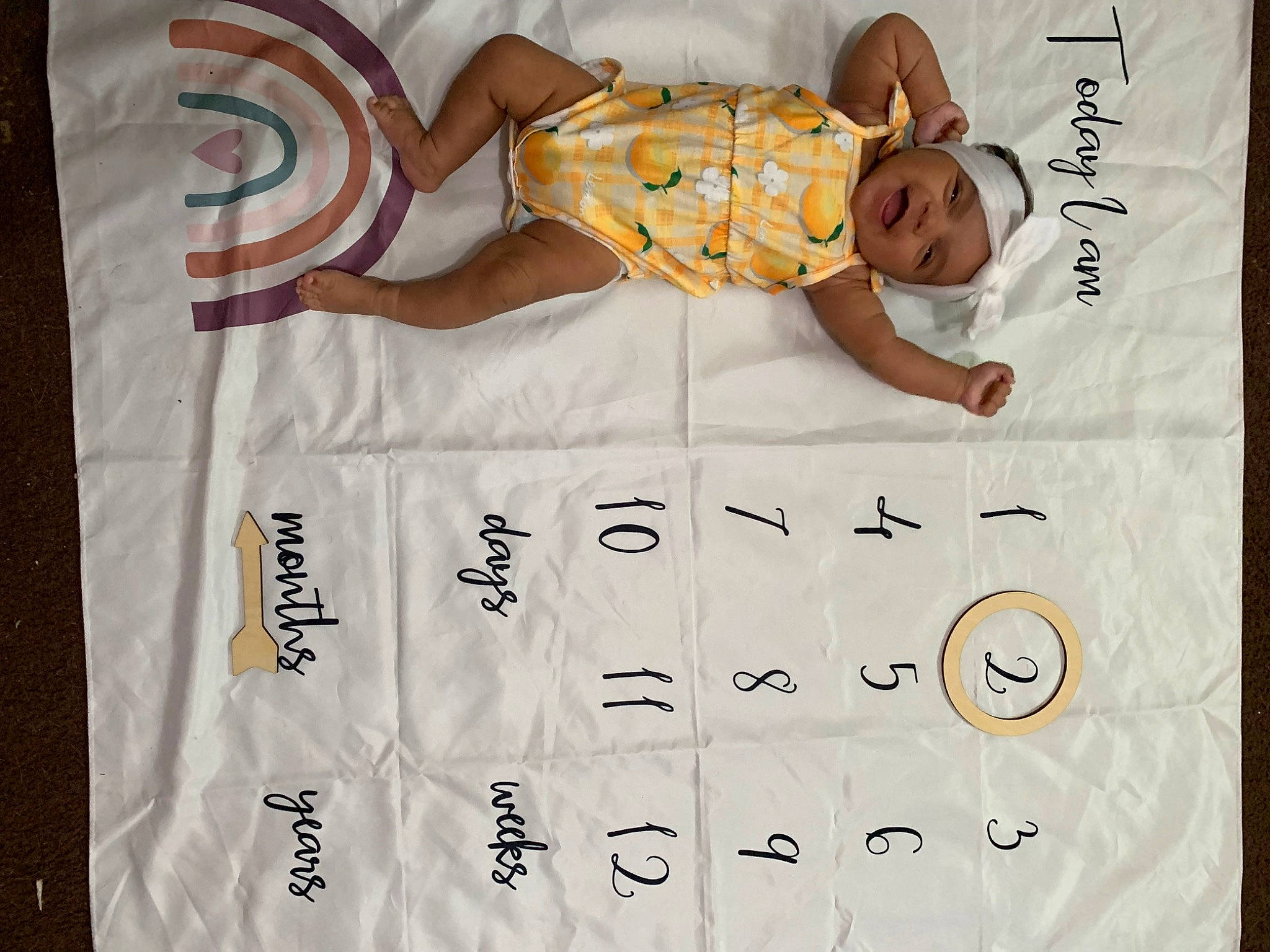 Enslee is registered to the contest to win money with this photo: baby, baby_toddler_clothing, calendar, child, comfort, font, handwriting, happy, headwear, linens, number, pattern, person, rectangle, room, sleeve, smile, textile, toddler, white
