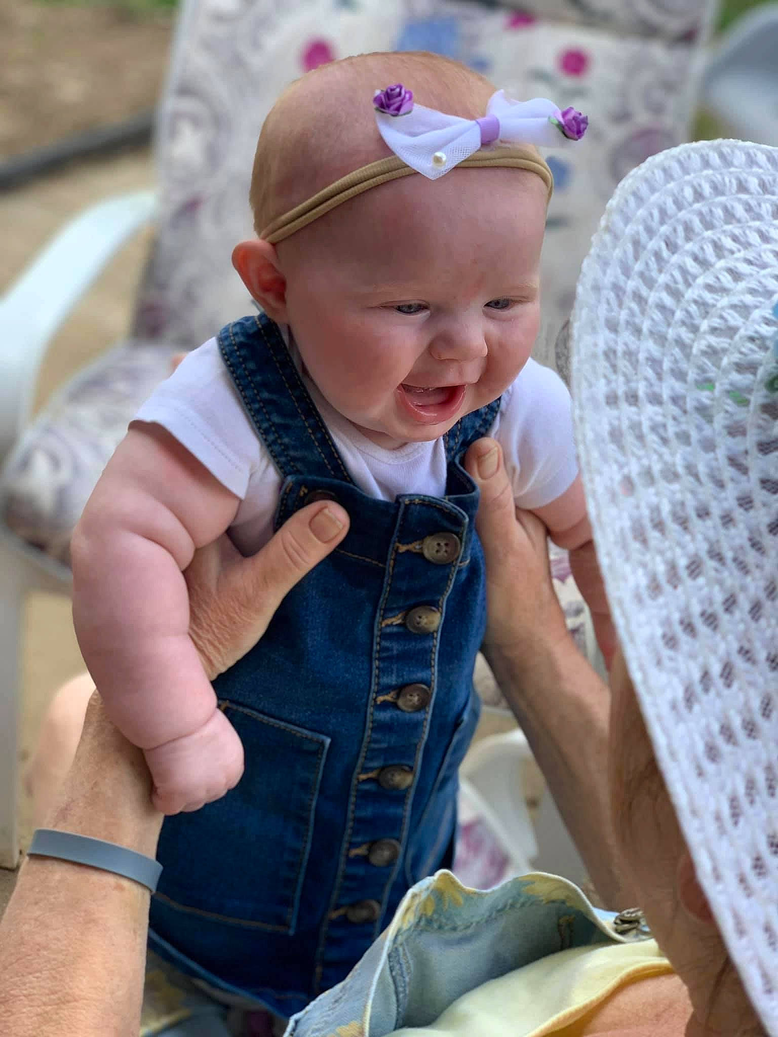 Kinlee is registered to the contest to win money with this photo: baby, baby_toddler_clothing, cap, child, face, facial_expression, finger, fun, grass, happy, hat, leisure, pattern, person, photograph, product, sitting, skin, smile, summer