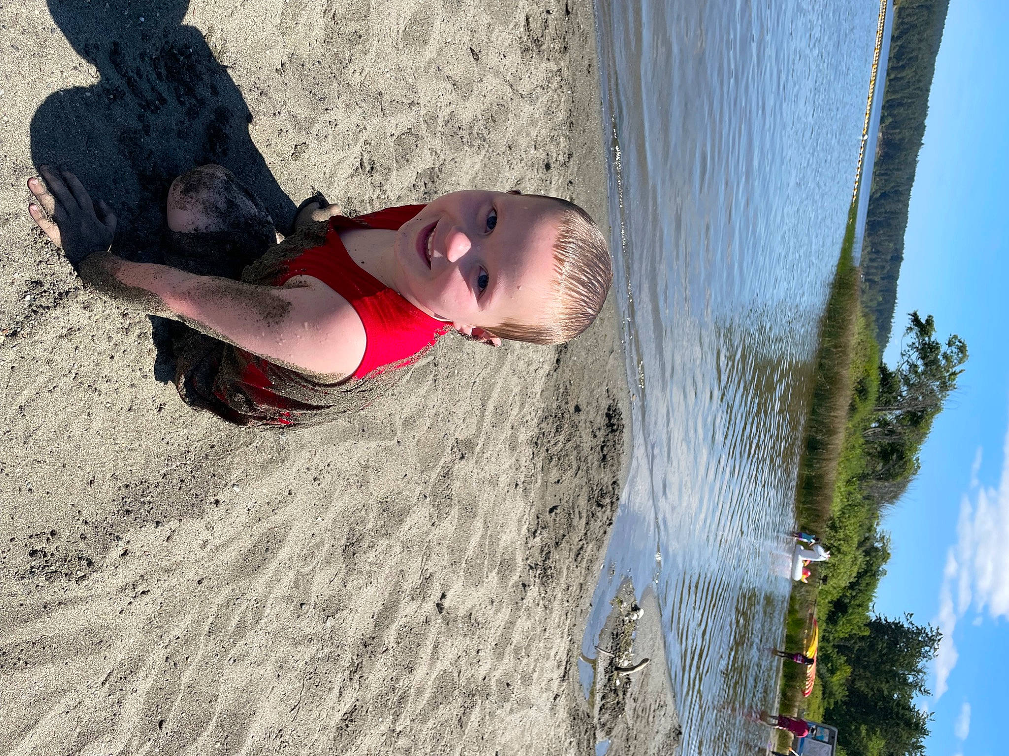 Jeremy is registered to the contest to win money with this photo: beach, carmine, child, fun, happy, human_leg, joy, lake, landscape, leisure, people_in_nature, person, recreation, reflection, rock, sky, soil, thigh, toddler, tree