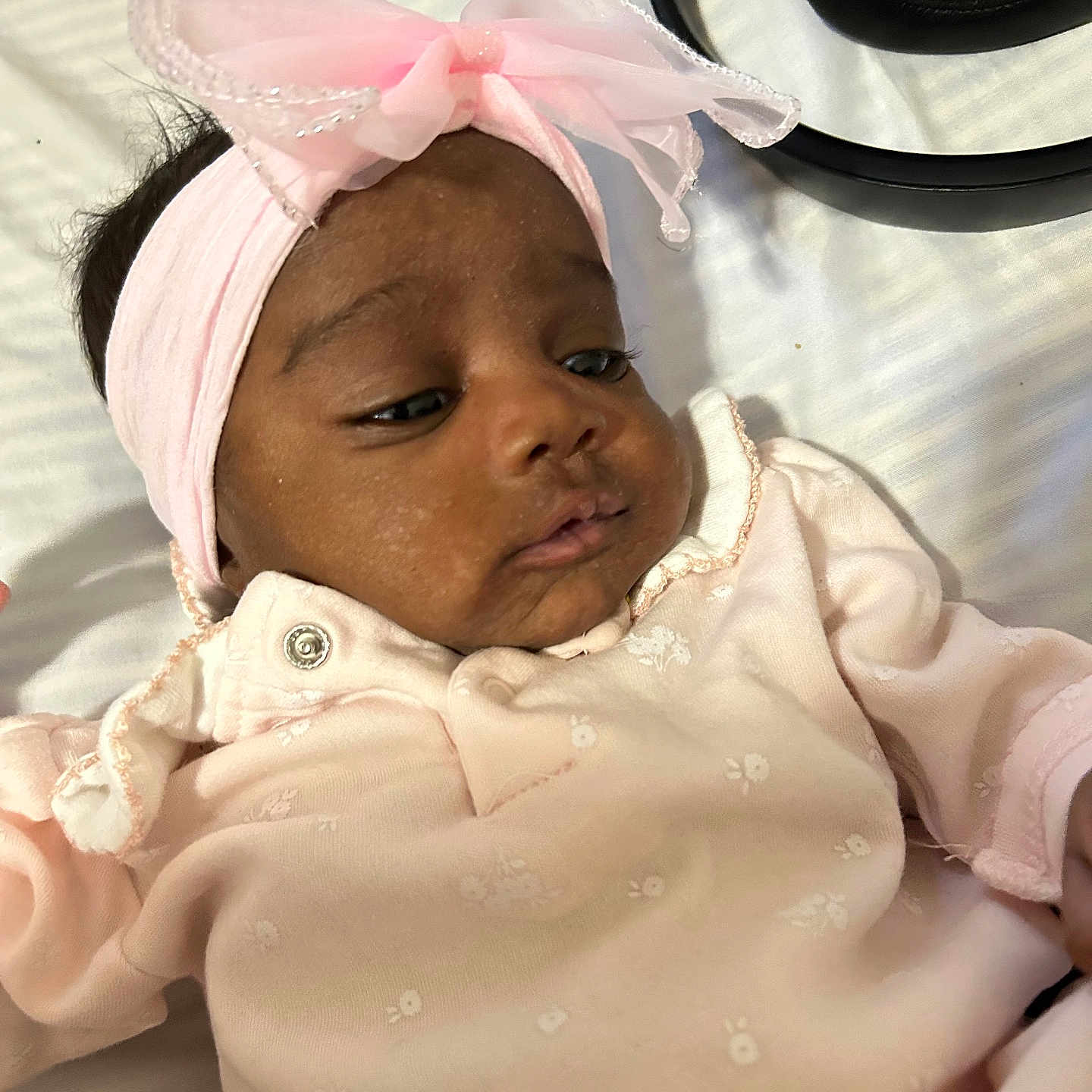 Zolani is registered to the contest to win money with this photo: baby, baby_girl, bow, closeup, curious, cute, face, headband, headphones, indoor, infant, lying_down, peaceful, pink_clothing, portrait, relaxed, skin, sleepwear, soft_light, young_child