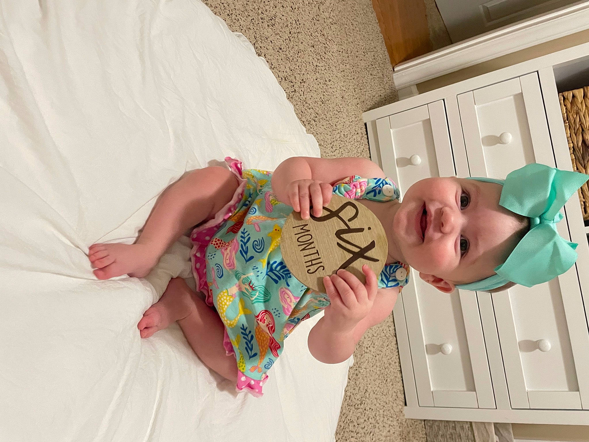 Hensley is registered to the contest to win money with this photo: arm, baby, baby_products, baby_toddler_clothing, child, comfort, finger, hand, happy, headwear, linens, pattern, person, pink, room, skin, smile, textile, thumb, toddler
