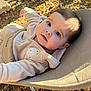 baby, child, outdoor, sunlight, fall_leaves, earth, chair, clothing, face, person, young_child, curious, cozy, beige, nature, daylight, portrait, infant, relaxing, casual