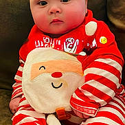 Braxton joined the competition — help win amazing prizes! baby, infant, child, face, red_clothing, striped_clothing, santa, christmas, holiday_outfit, couch, indoor, cute, plush, smiling_santa, sitting, cozy, soft_toy, blanket, festive, portrait