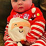 baby, infant, child, face, red_clothing, striped_clothing, santa, christmas, holiday_outfit, couch, indoor, cute, plush, smiling_santa, sitting, cozy, soft_toy, blanket, festive, portrait