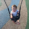 toddler, child, swing, playground, outdoor, seat, chain, rubber_surface, bench, grass, sunlight, shadow, barefoot, short_sleeve, serious_expression, young_child, daytime, park, play, person