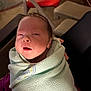 Braxton joined the competition — help win amazing prizes! baby, infant, towel, wrapped, sleepy, indoor, person, face, head, newborn, cozy, blanket, soft, hand, seated, red_chair, furniture, light, portrait, cute