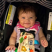 Vera is registered to the contest to win money with this photo: baby, car_seat, child, smile, happy, face, clothing, striped_canopy, animal_print, harness, infant, cute, purple_shirt, floral_pants, seatbelt, indoor, person, young_child, sitting, closeup