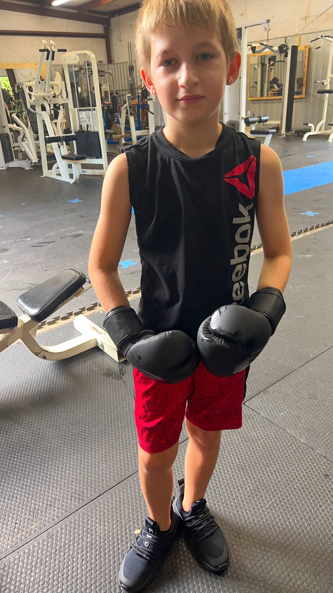 Riley is registered to the contest to win money with this photo: chest, elbow, eyewear, fashion, hairstyle, joint, knee, muscle, person, photograph, shoe, shorts, shoulder, sleeveless_shirt, sneakers, sportswear, standing, thigh, trunk, waist