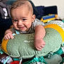 baby, smile, cushion, toy, blanket, indoor, child, face, hand, clothing, comfort, playtime, infant, happy, person, soft, home, cute, portrait, colorful