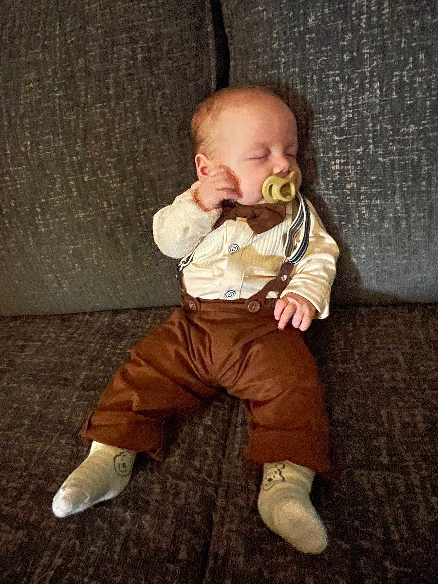 Henry joined the competition — help win amazing prizes! baby, sleeping, pacifier, suspenders, brown_pants, white_shirt, socks, couch, furniture, infant, child, resting, indoors, cute, person, portrait, cozy, soft_lighting, small_hands, relaxed