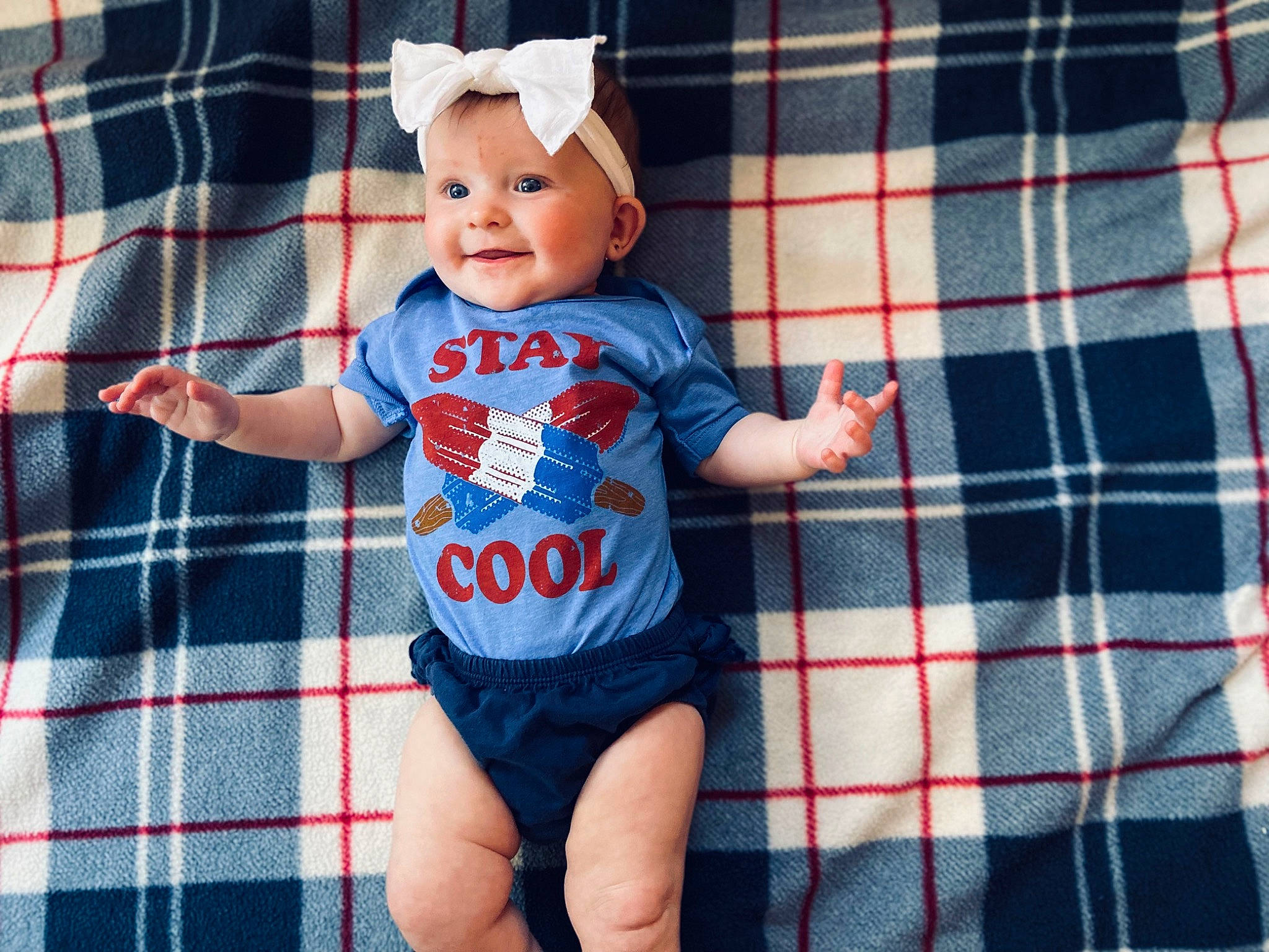 Harper is registered to the contest to win money with this photo: baby, baby_products, baby_toddler_clothing, electric_blue, fun, happy, headwear, jersey, joy, linens, pattern, person, plaid, shorts, sleeve, smile, sportswear, t_shirt, tartan, textile