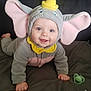 baby, blue_eyes, child, crawling, cute, elephant_costume, face, gray_background, hand, happy, hooded_outfit, indoors, infant, pacifier, pink_ears, playful, portrait, smiling, soft_blanket, yellow_hat