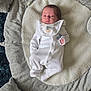 baby, blanket, comfortable, cozy, cute, face, footed_pajamas, gray_blanket, head, indoor, infant, lying_down, newborn, onesie, padded_mat, resting, sleepwear, small_hands, soft, white_clothing