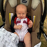 Wylder joined the competition — help win amazing prizes! baby, infant, car_seat, blanket, outdoor, grass, clothing, smile, face, person, seat_belt, head, hand, legs, fabric, cute, happy, child, child_in_car_seat, baby_clothes